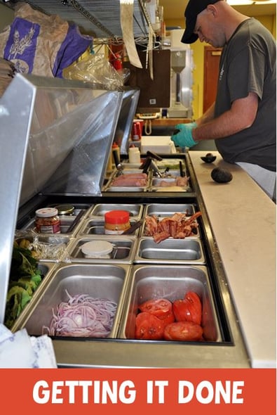 Photo of a sandwich cooler with fresh ingredients and the text "getting it done"