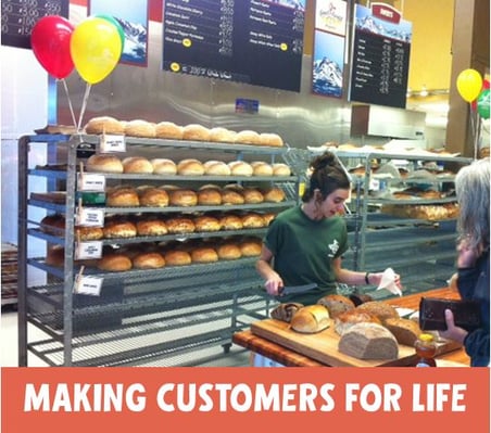 photo of a rack of bread and a bakery employee